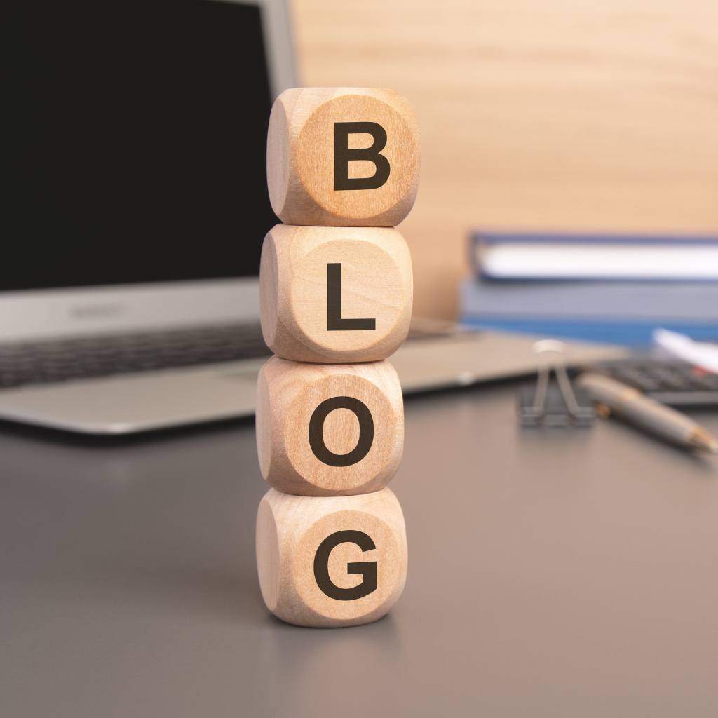 Holzwürfel mit den Buchstaben B, L, O und G aufeinandergestapelt