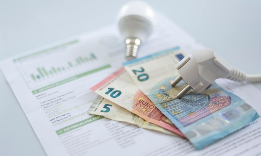 Geldscheine und eine Glühbirne liegen auf einer Rechnung